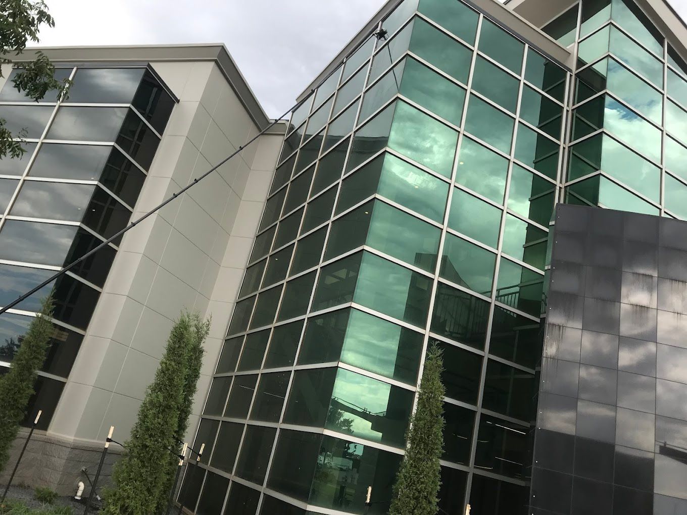 A large building with lots of windows and trees in front of it