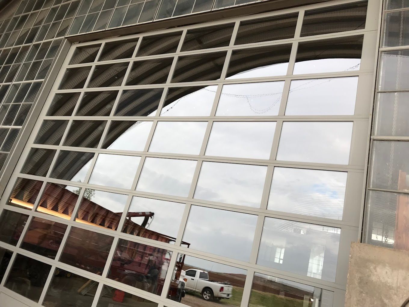 A truck is reflected in the windows of a building.