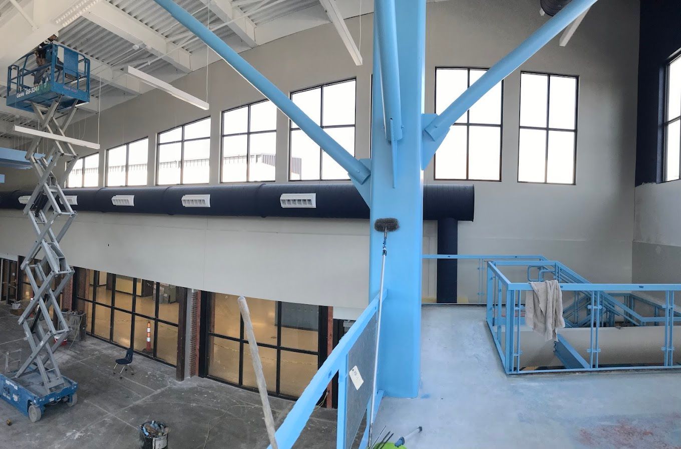 A building with a lot of windows and a blue pillar