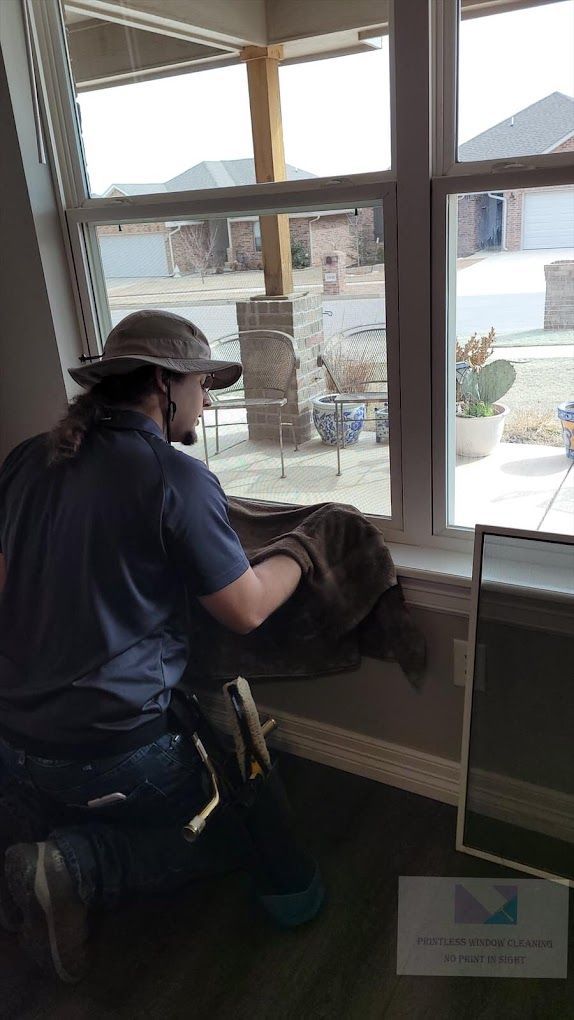 A man is kneeling down in front of a window.