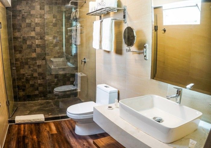 Baño moderno con ducha de cristal, lavabo blanco e inodoro.