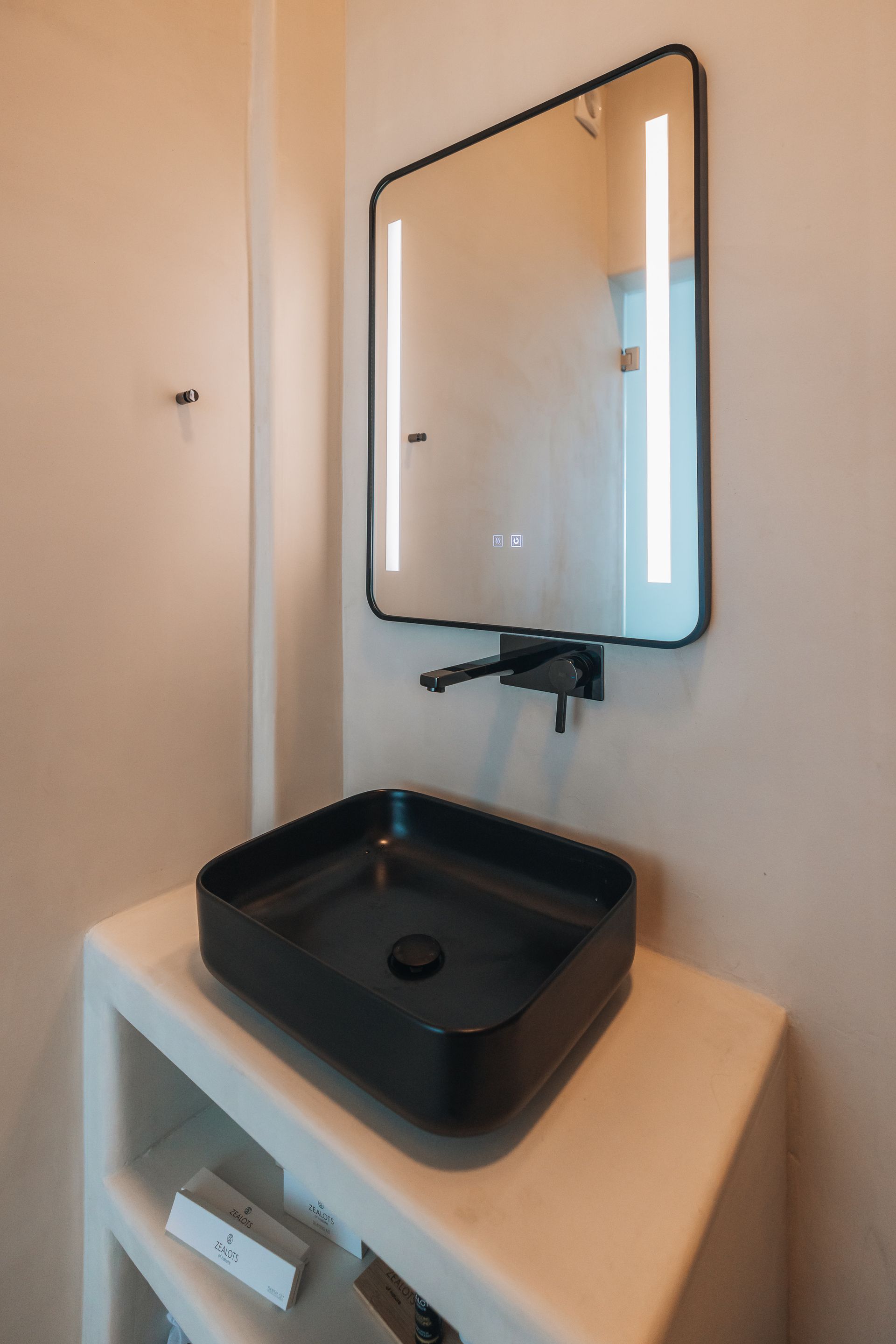 A bathroom with a black sink and a mirror