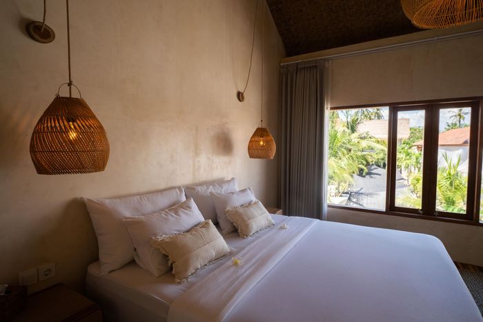 There is a bed in the middle of the room with a window.