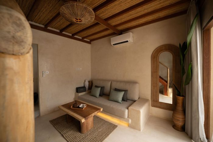 A living room with a couch , coffee table and mirror.