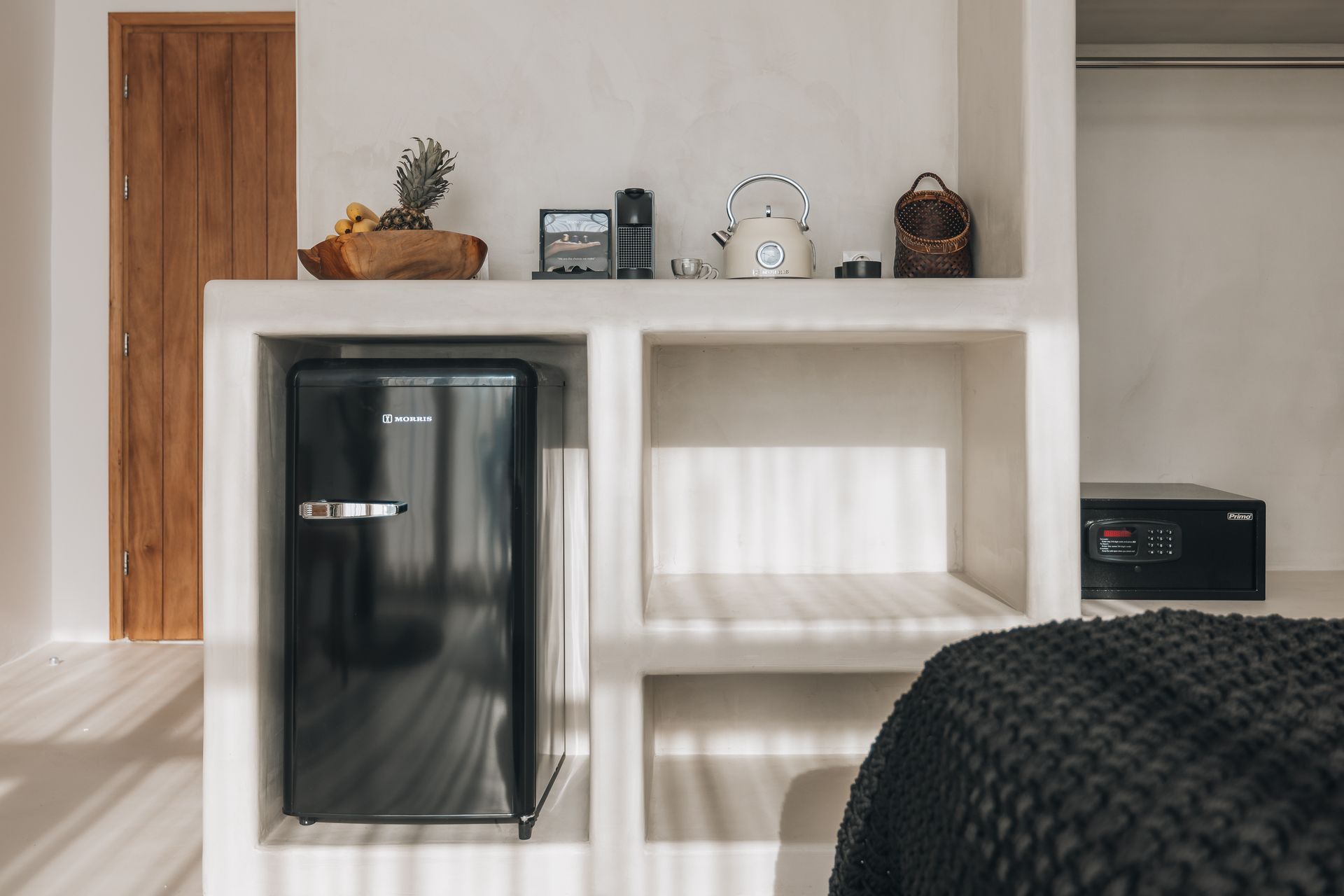 There is a small refrigerator in the corner of the room.