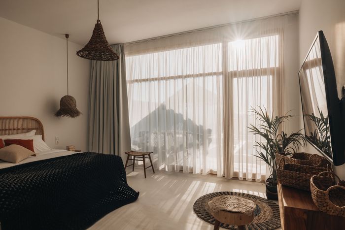 A bedroom with a large window and a bed.
