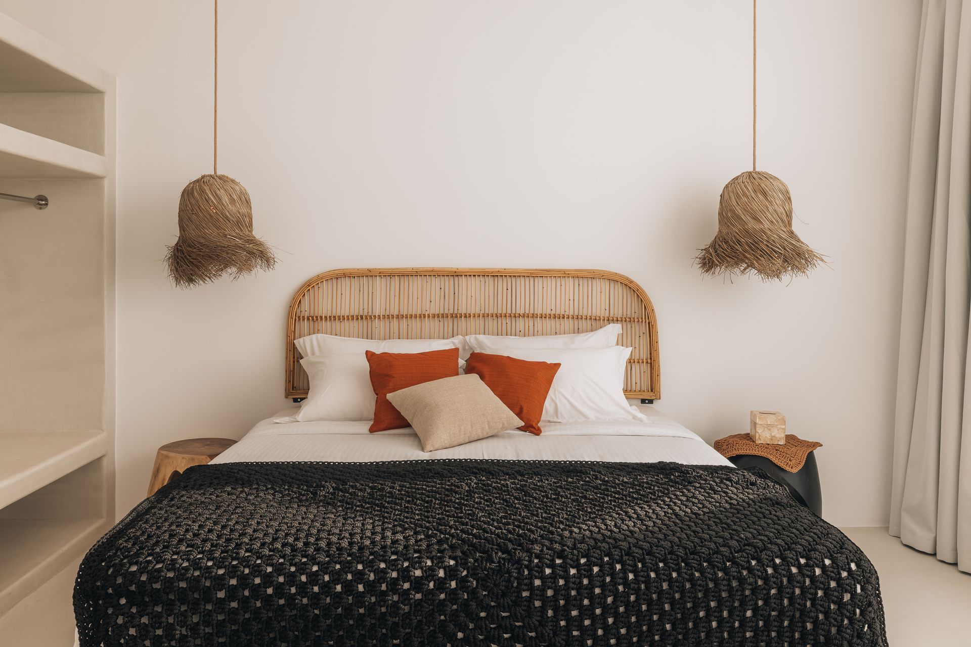 A bed with a wicker headboard and pillows in a bedroom.
