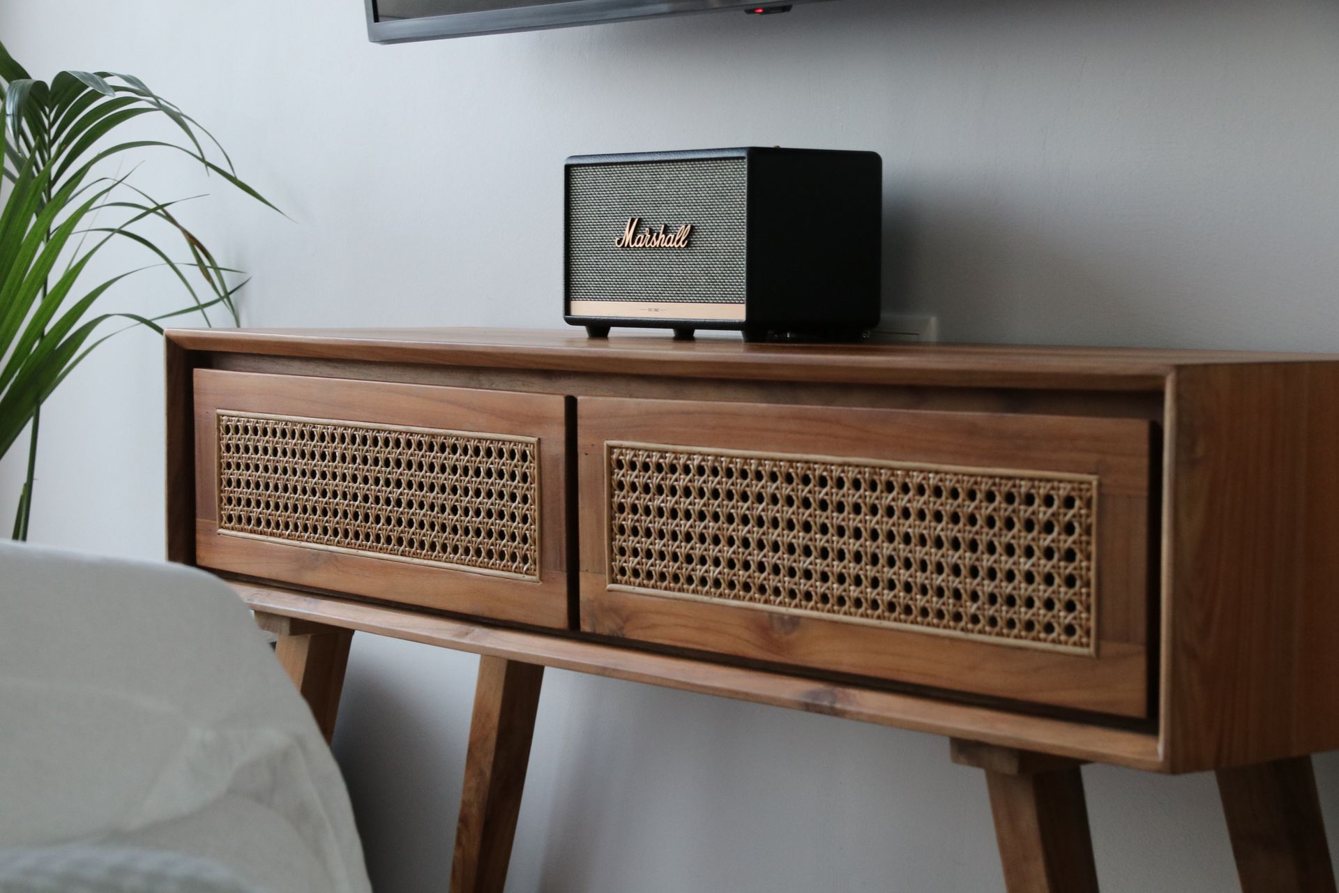 A marshall speaker is sitting on top of a wooden table.