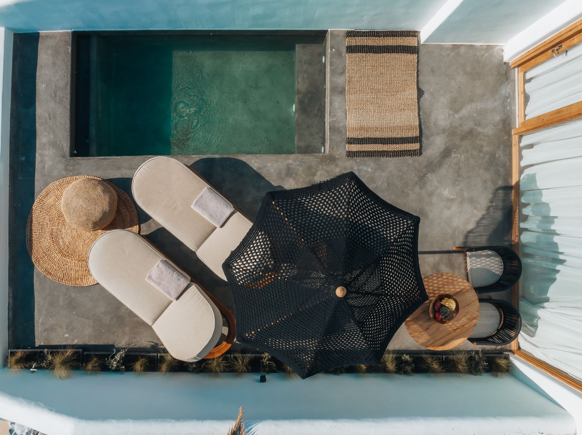 An aerial view of a swimming pool with chairs and umbrellas.