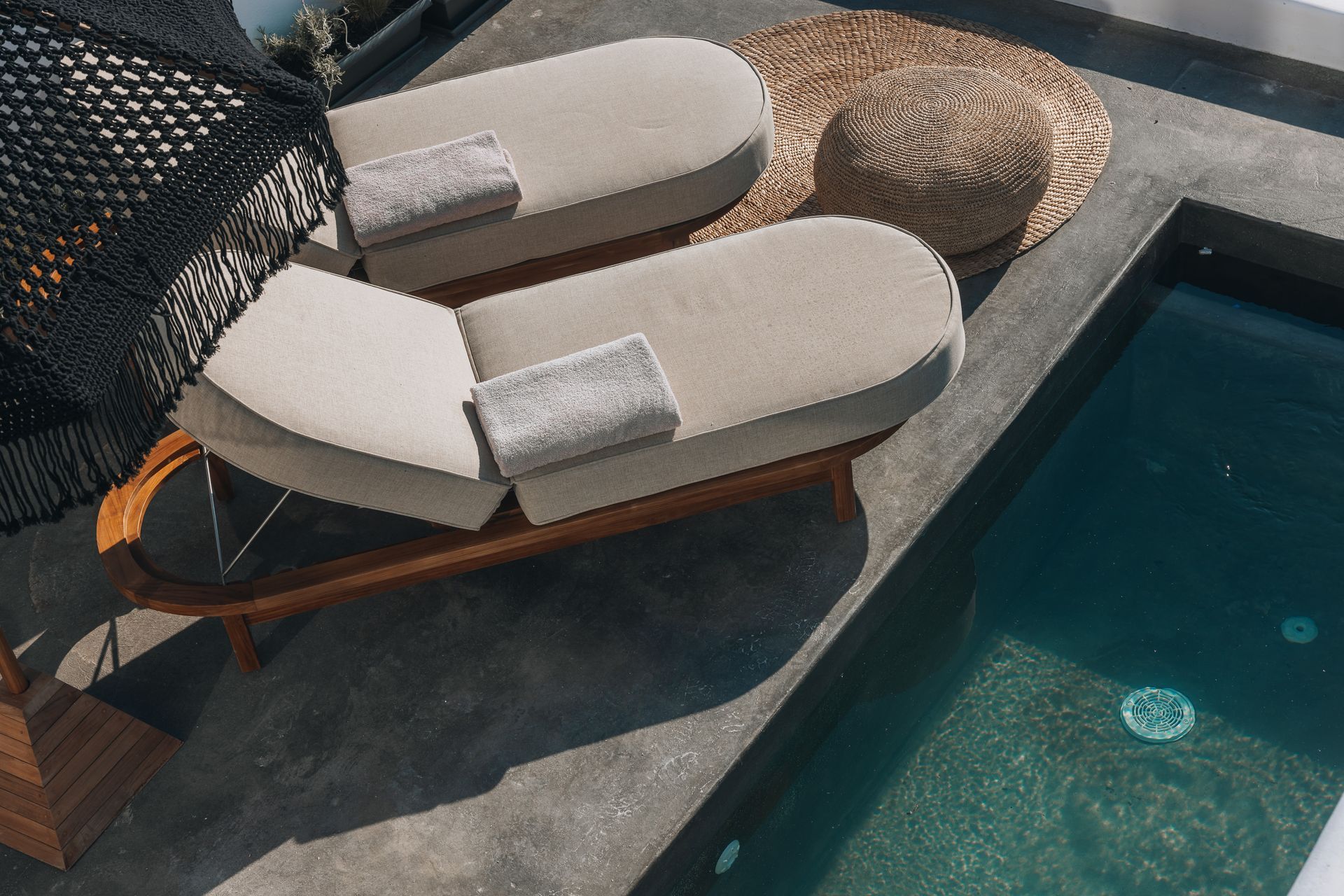 Two lounge chairs are sitting next to a swimming pool.