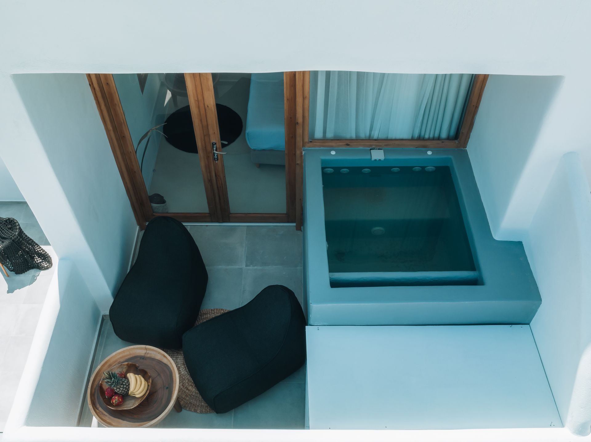 An aerial view of a balcony with a jacuzzi and a table.