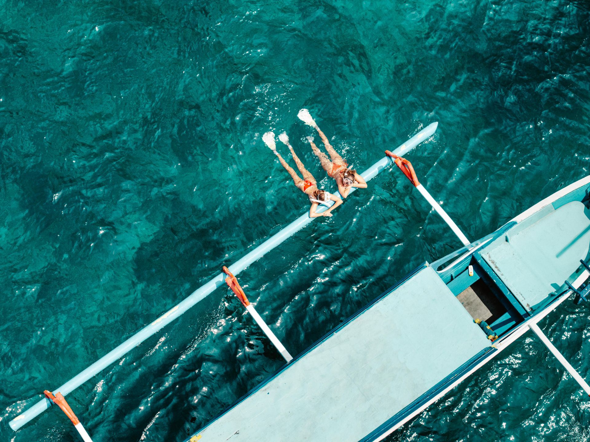 An aerial view of two people on a boat in the ocean