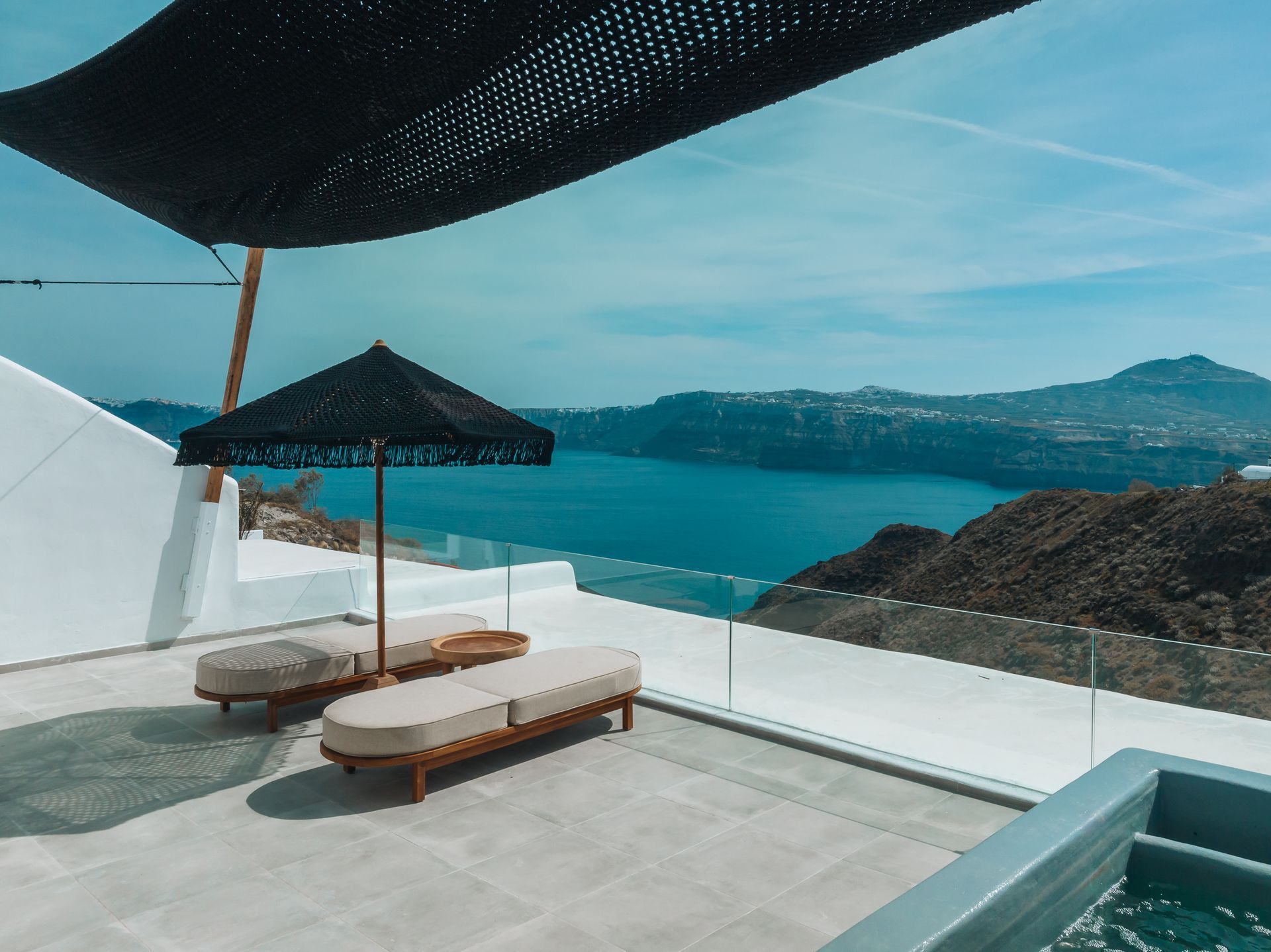 A patio with chairs and umbrellas overlooking the ocean.