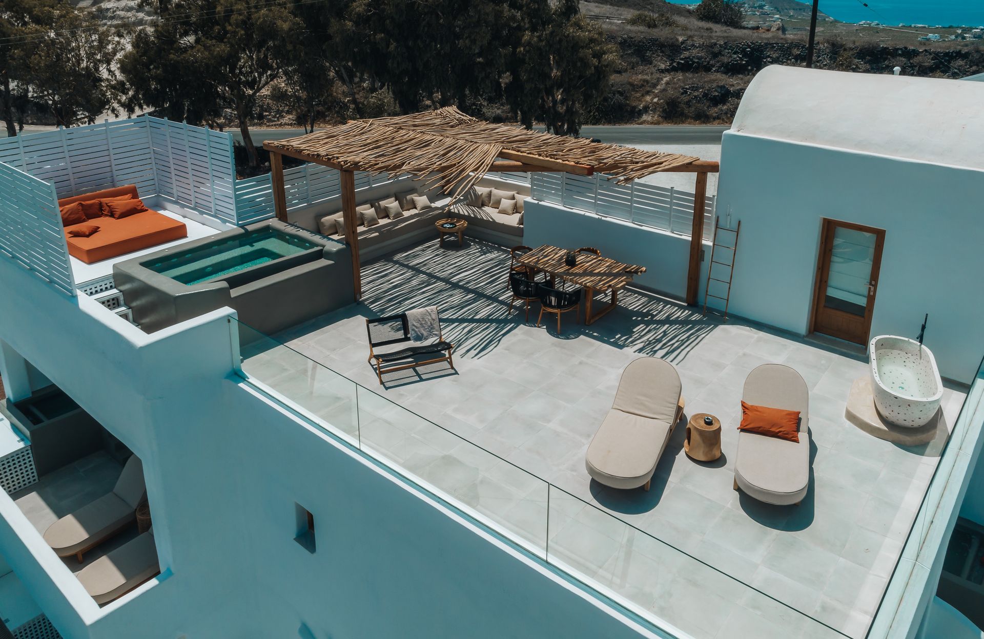 An aerial view of a rooftop terrace with a pool and chairs.