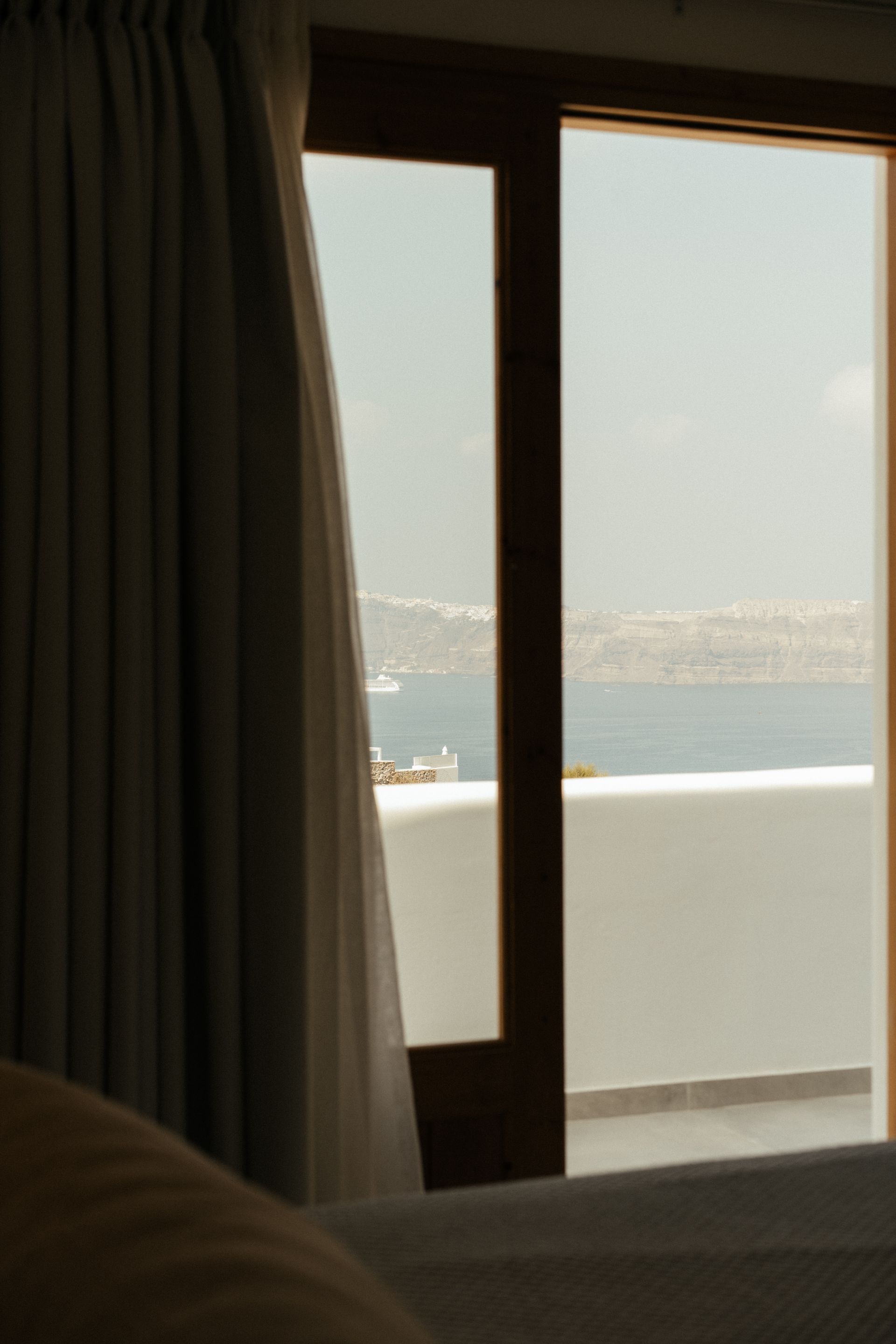 A bedroom with a view of the ocean through a window