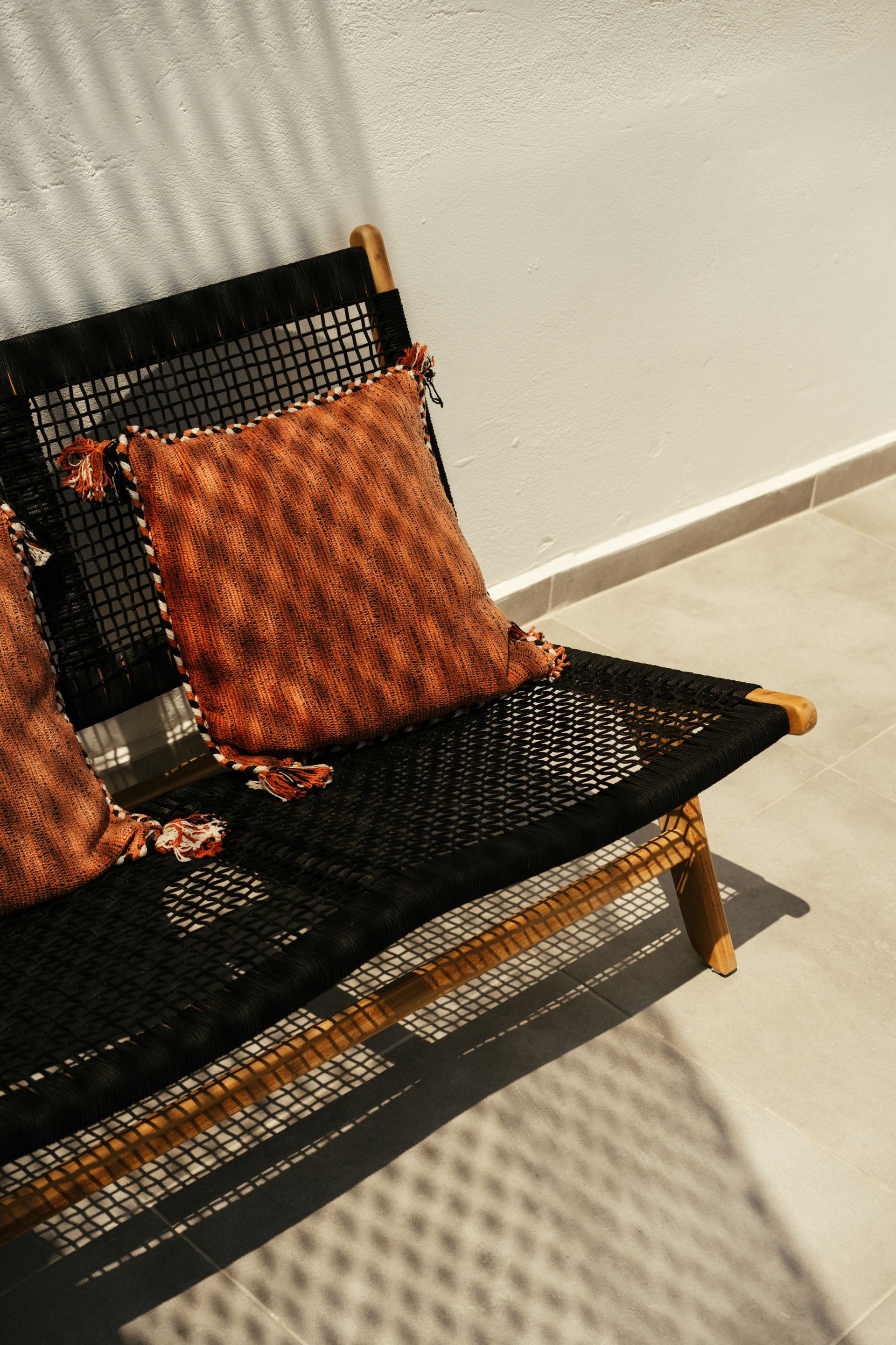 A black chair with two pillows on it in a room.