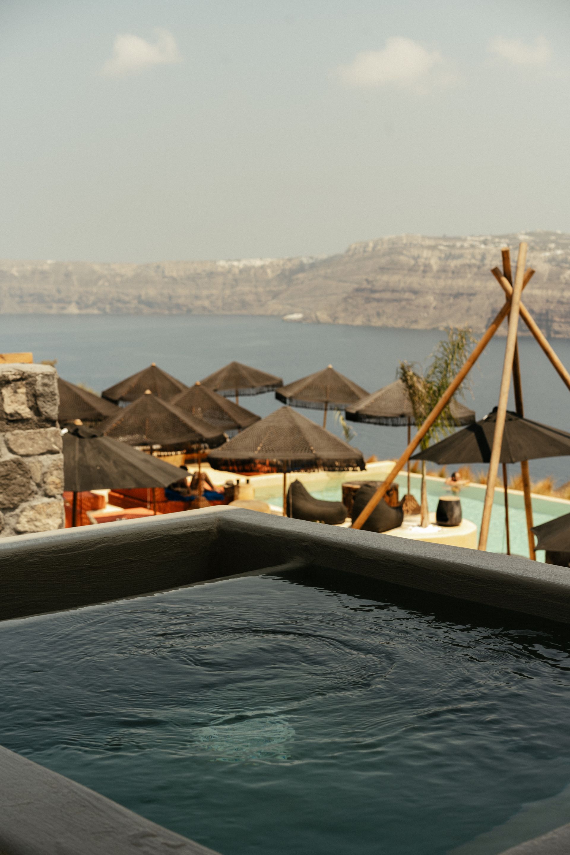 A swimming pool with umbrellas and a view of the ocean