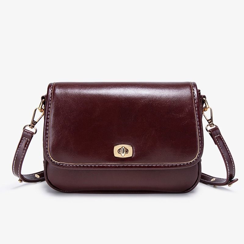 Bolso de hombro de piel marrón oscuro con correa larga, cierre dorado y costuras blancas.