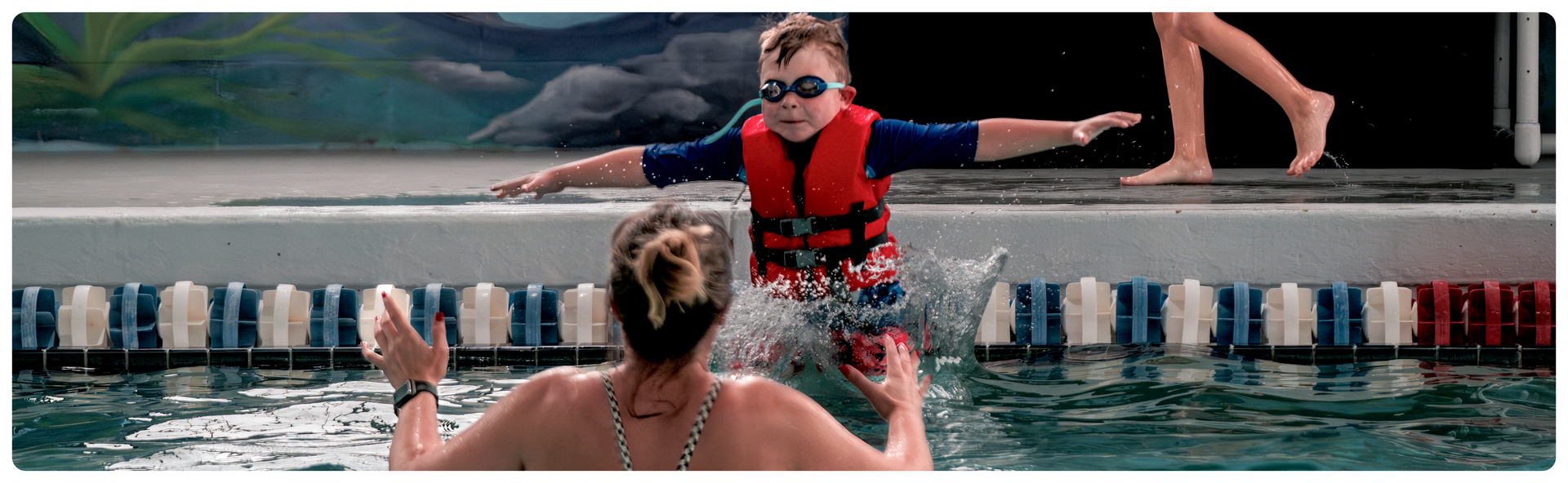 small child with swimming instructor