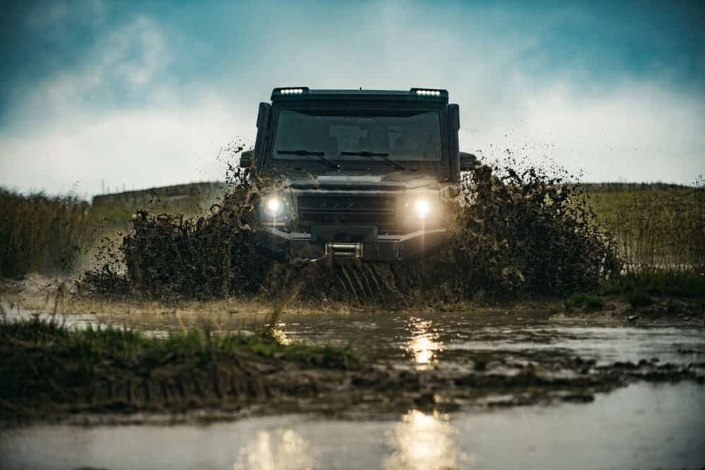 A Truck Is Driving Through A Muddy Puddle — Wilson's Towing In St George, QLD