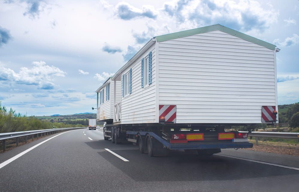 A Truck Is Carrying A Mobile Home Down A Highway — Wilson's Towing In Pittsworth, QLD