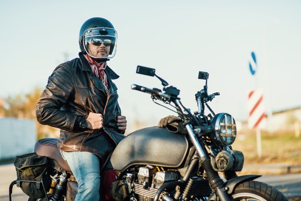 A Man In A Leather Jacket And Helmet Is Sitting On A Motorcycle — Wilson's Towing In Gatton, QLD