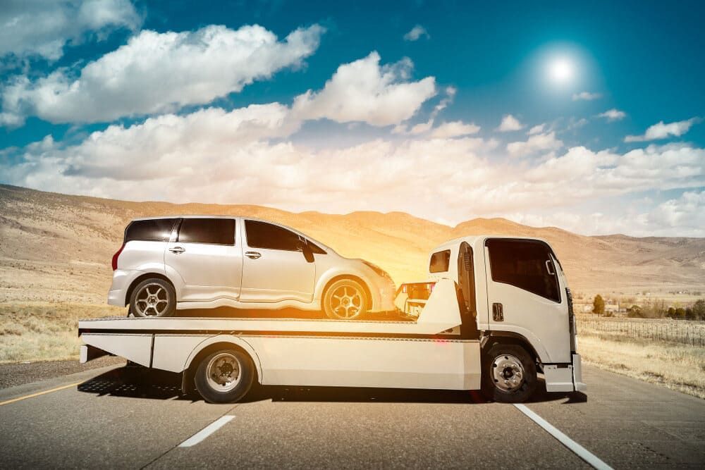 A Tow Truck Is Carrying A Van On The Back Of It — Wilson's Towing In Maryborough, QLD