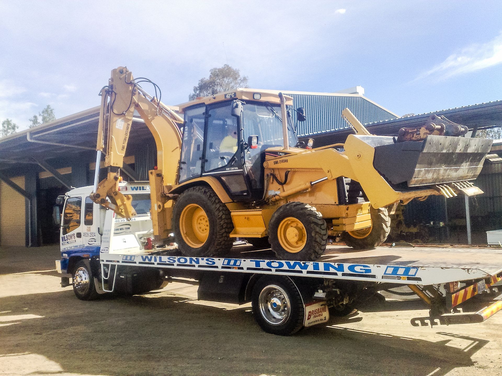 Tow Truck Towing a Tractor — Wilson's Towing In North Toowoomba, QLD