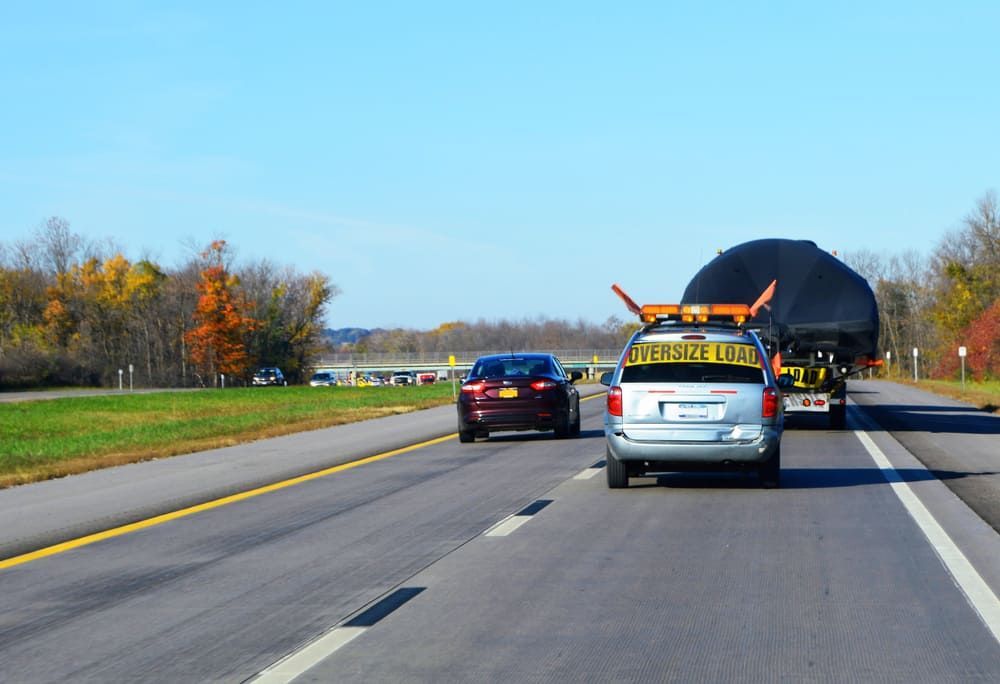 A Tow Truck Is Driving Down The Highway With A Large Object On The Back Of It — Wilson's Towing In Pittsworth, QLD
