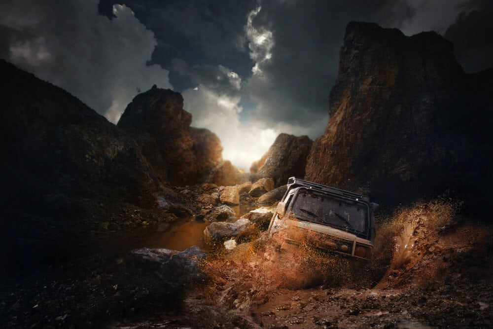 A Jeep Is Driving Through A Muddy Canyon In The Mountains — Wilson's Towing In North Toowoomba, QLD