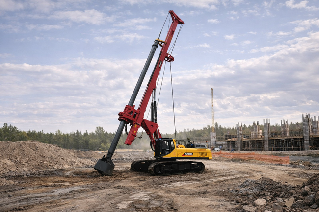 YUCHAI Red drilling rig on a construction site, drilling into the ground under a cloudy sky.