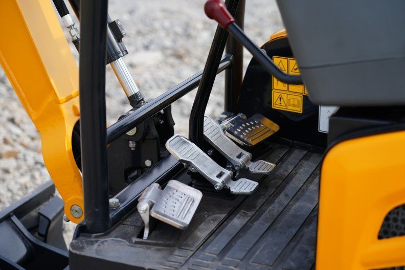 Yellow and black YUCHAI U17excavator pedals, controls, and frame.