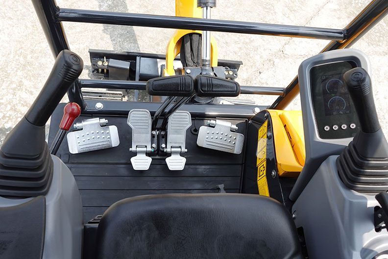Control panel inside a yellow construction YUCHAI U17 CAB. Levers, pedals, and a display screen are visible.