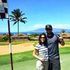 A man and a woman are posing for a picture on a golf course.