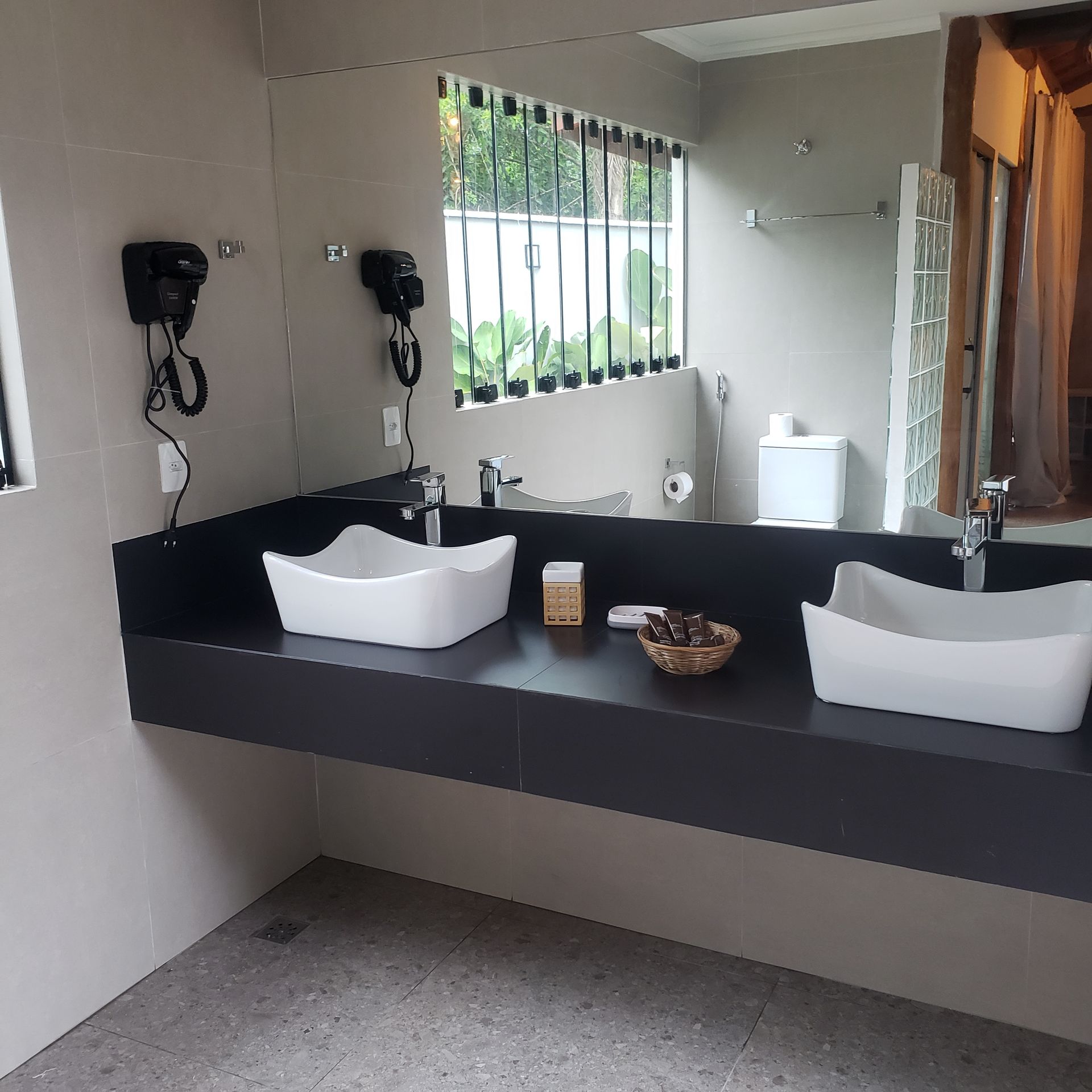 Um banheiro com duas pias e um espelho grande