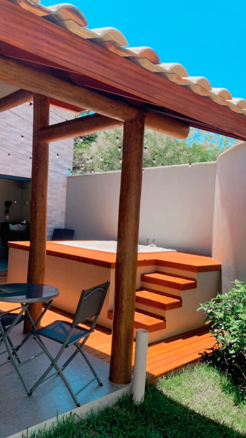 Há uma banheira de hidromassagem no quintal com escadas que levam até ela.