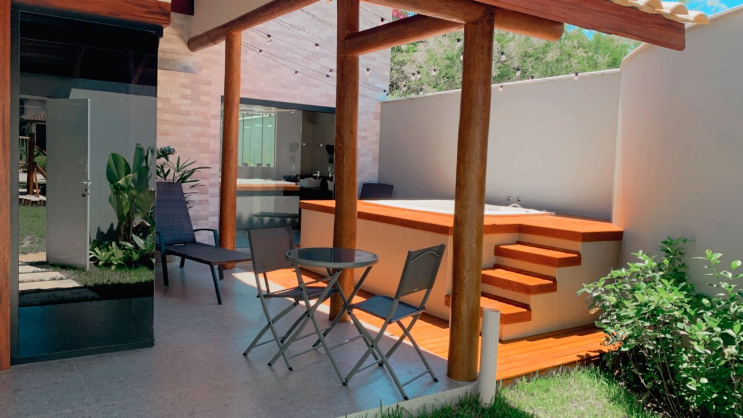 Um pátio com mesa e cadeiras e uma banheira de hidromassagem.