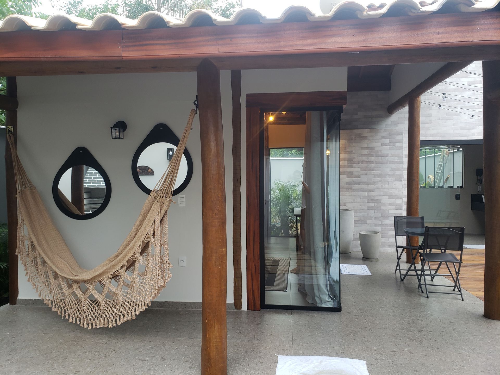 Uma rede está pendurada em um poste de madeira em frente a uma casa