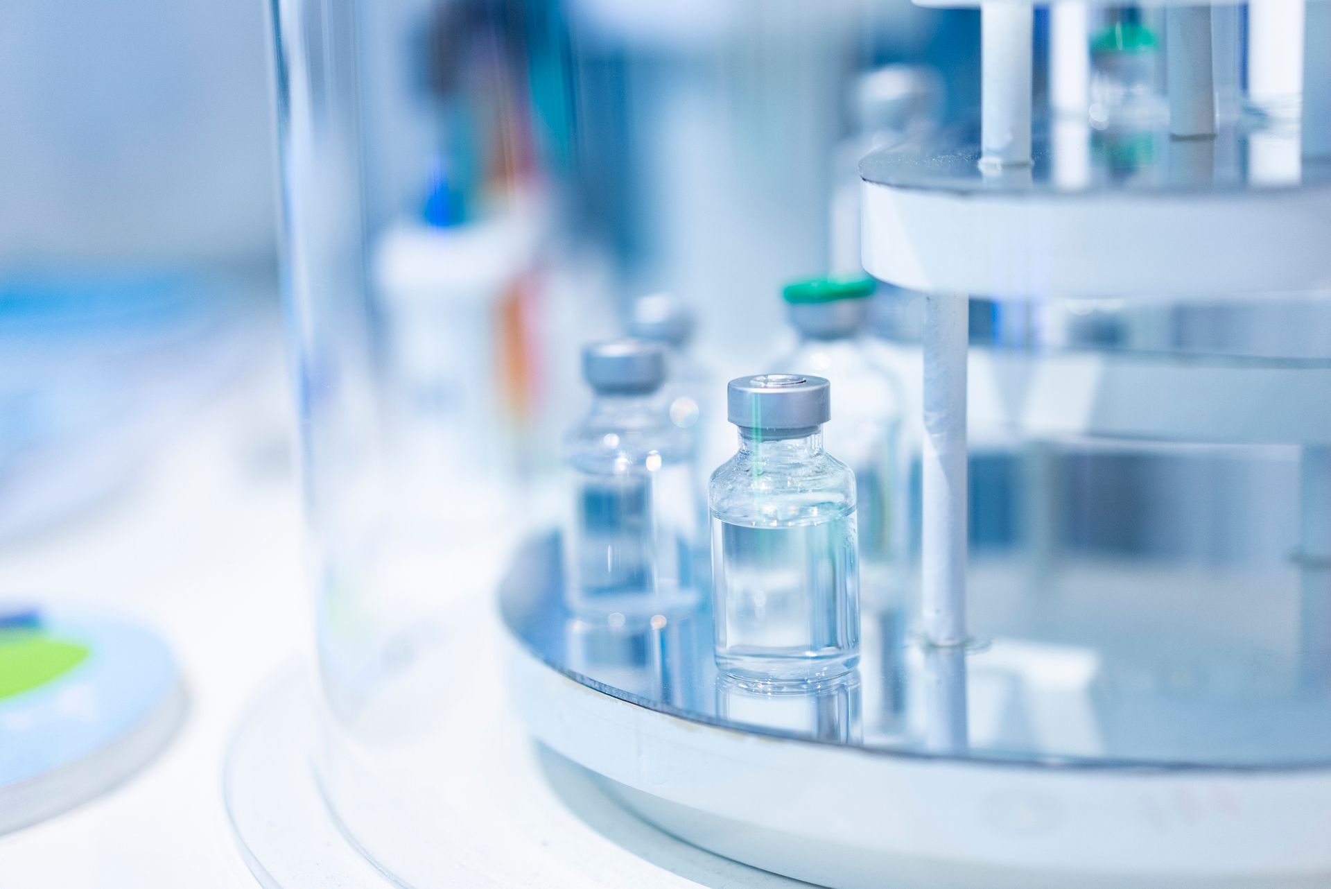 Glass vials with silver caps sit on a tray inside a laboratory machine.
