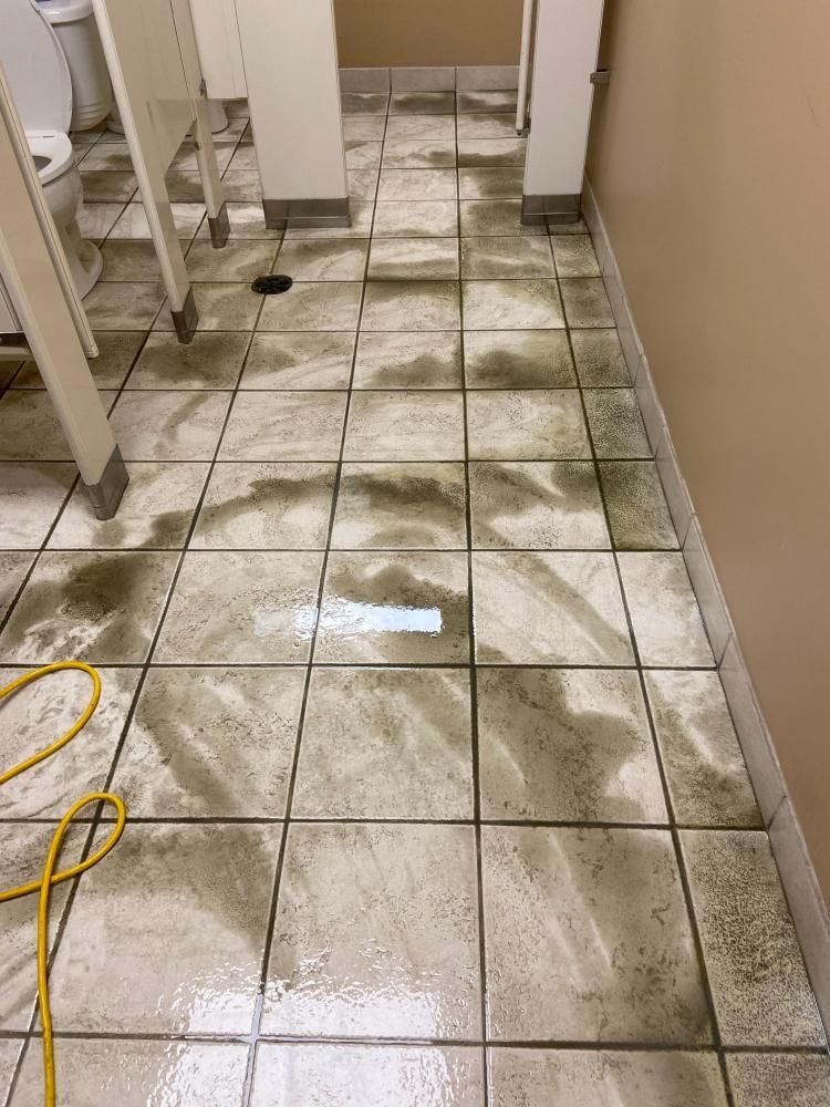 A bathroom floor with dirty tiles