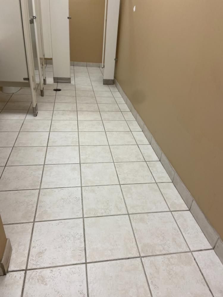 A bathroom with white tile floors, cleaned floor