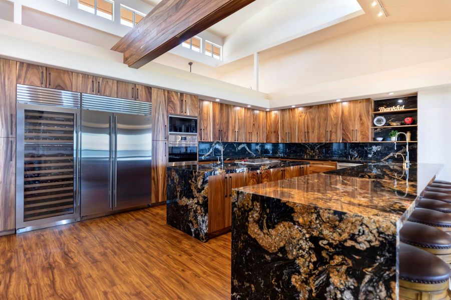 Luxurious kitchen with wood cabinets, granite countertops, and stainless steel appliances.