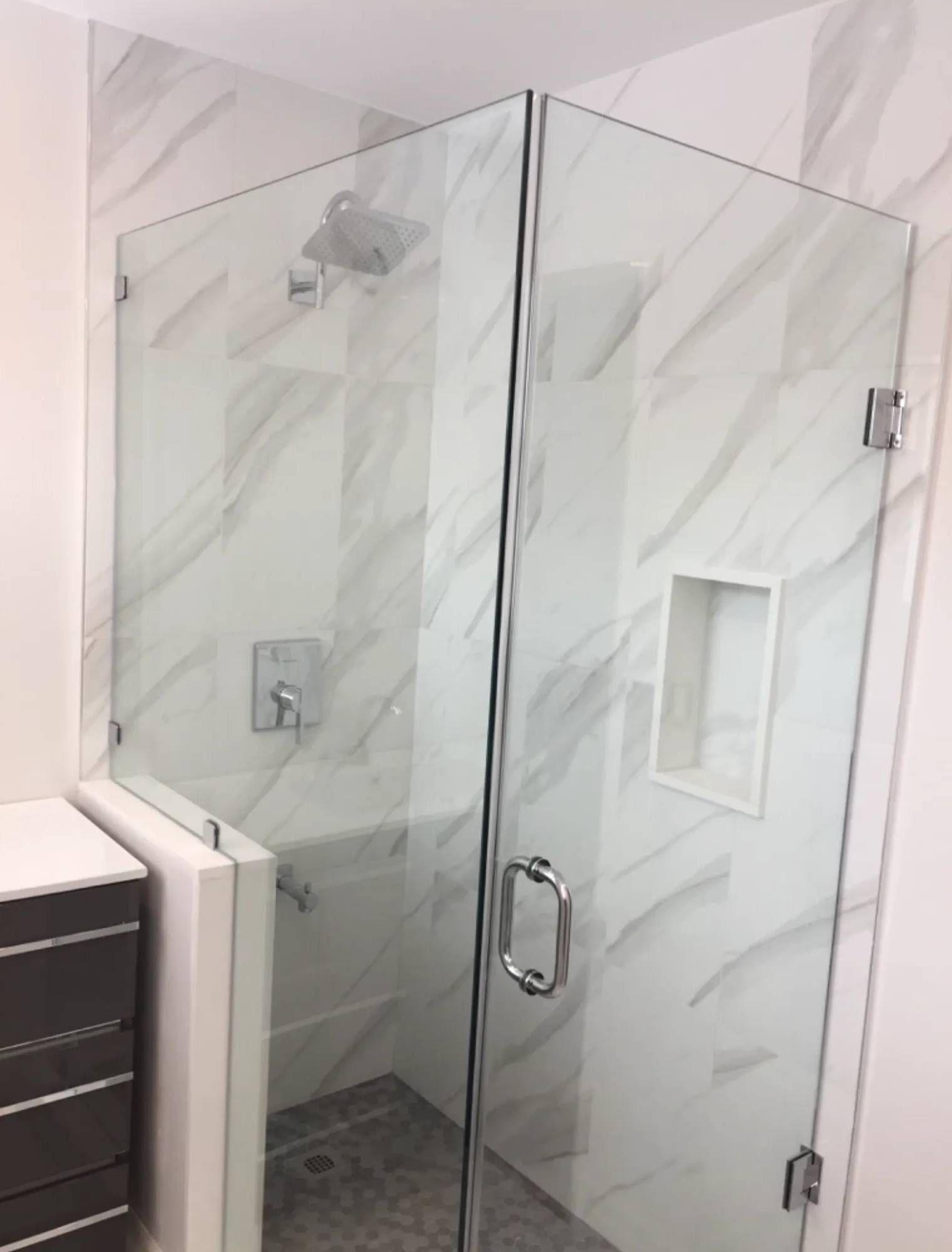 A bathroom with a glass shower door and a bathtub.