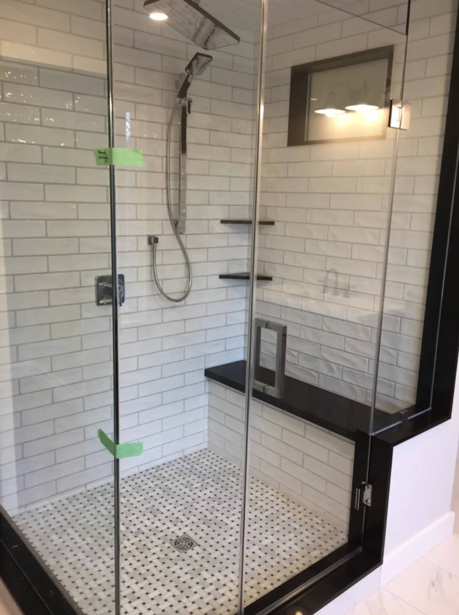 A bathroom with a walk in shower with a glass door.