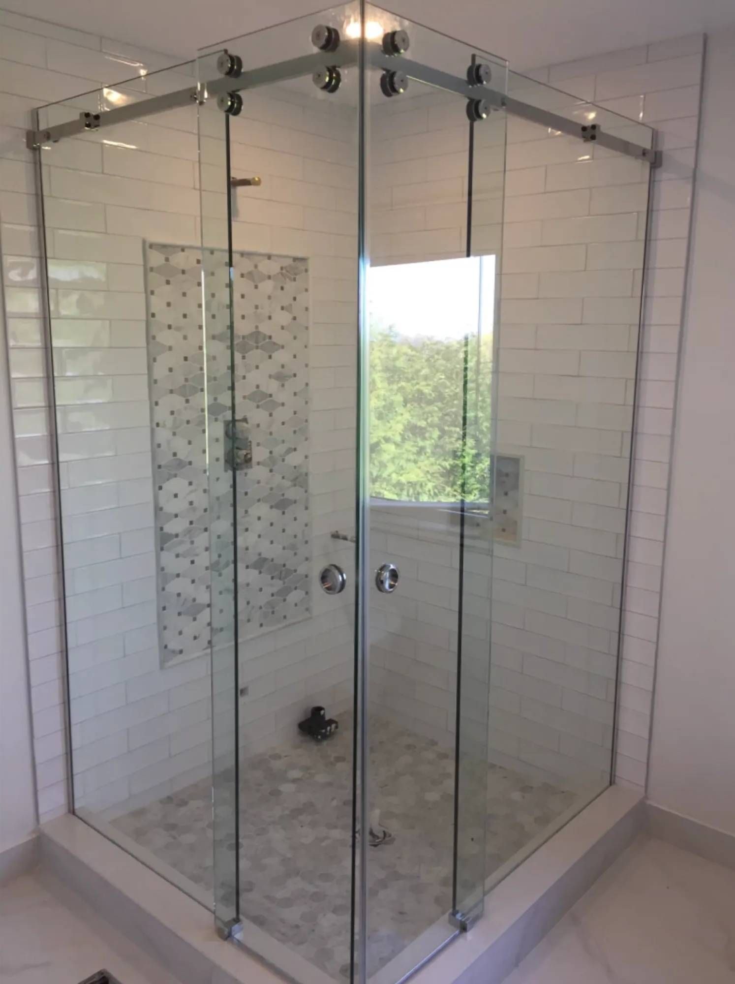 A shower stall with sliding glass doors in a bathroom