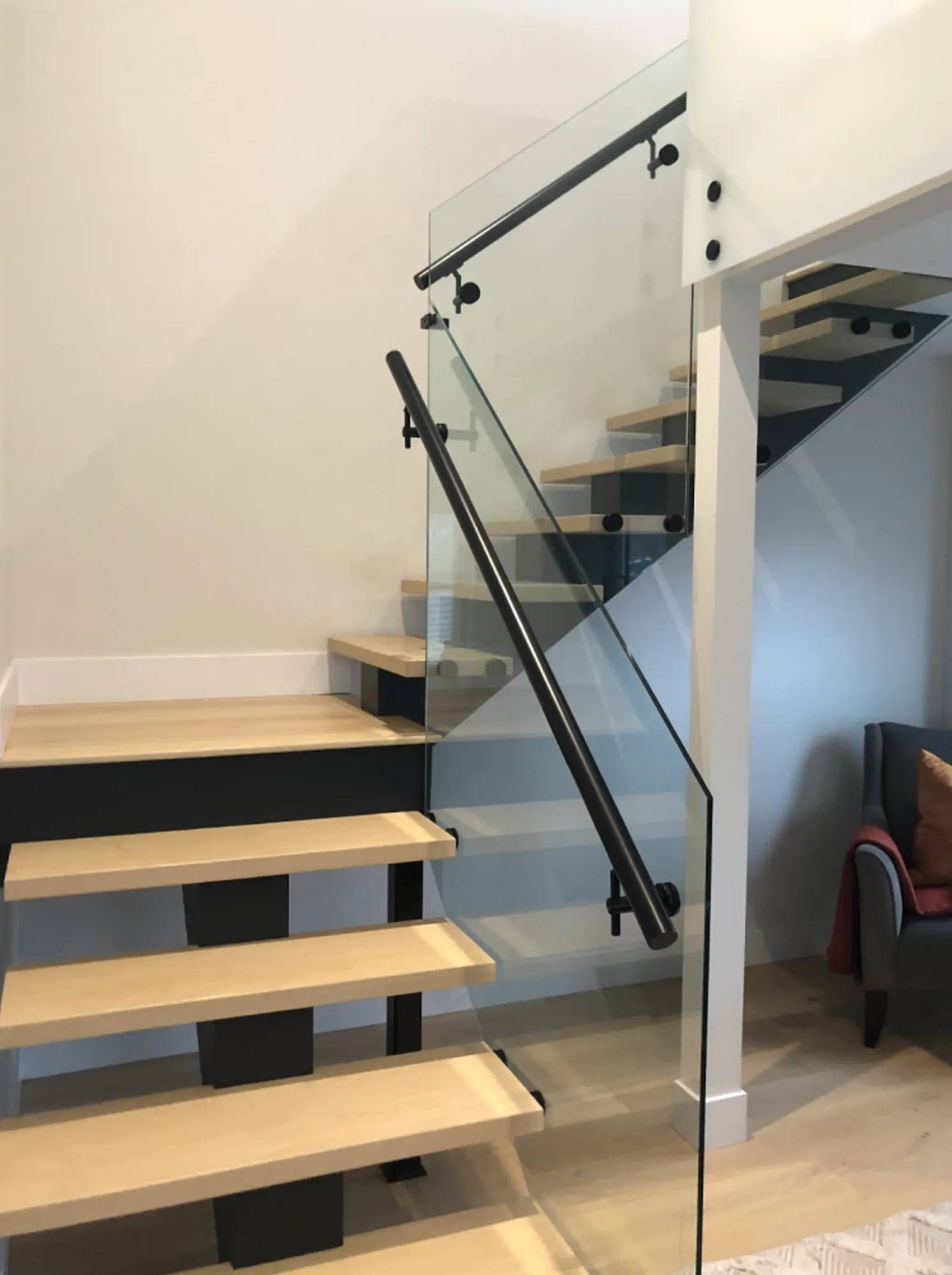 A staircase with a glass railing in a living room
