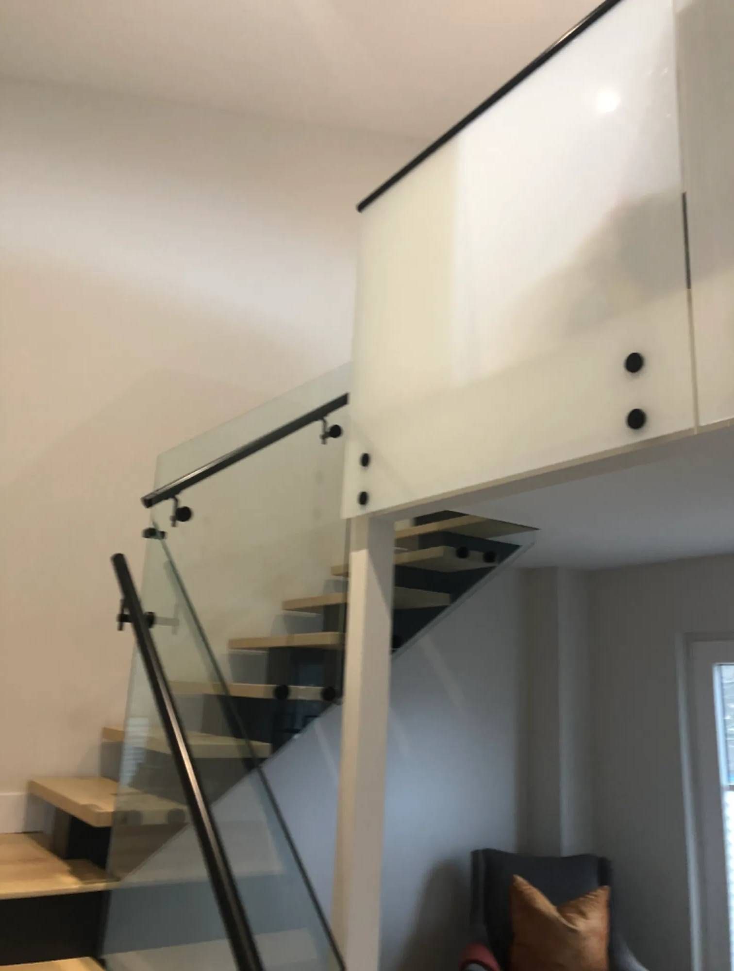A staircase with a glass railing in a living room