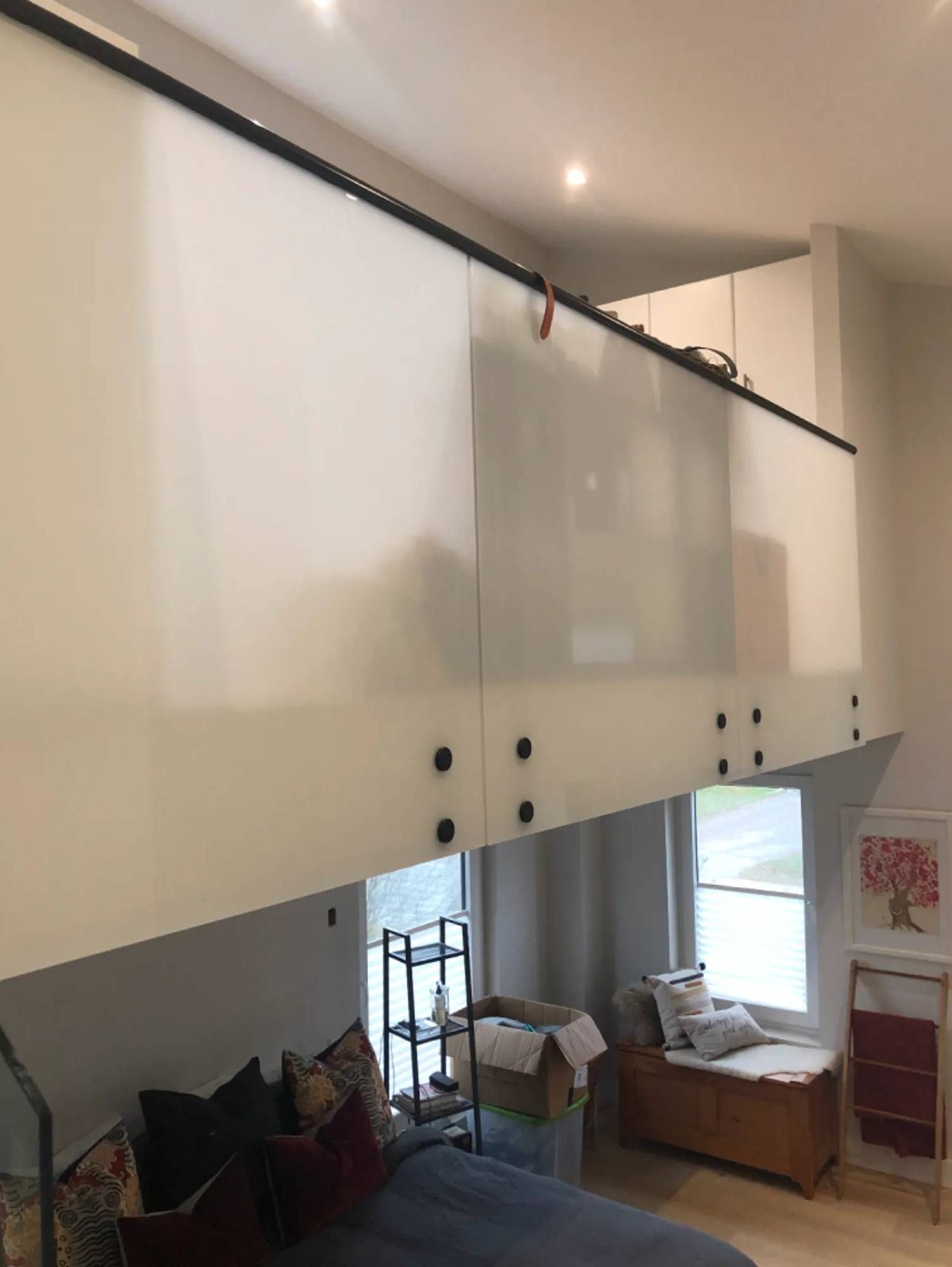 A bedroom with a bed and a box on the bench