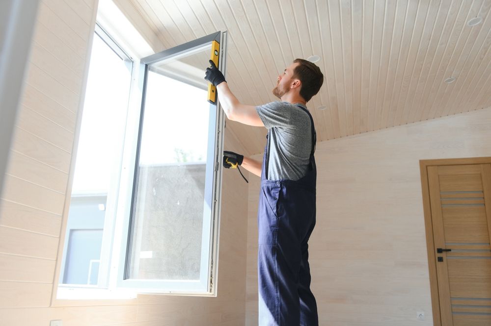 A man is installing a window in a room.
