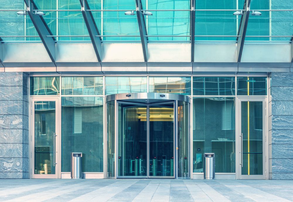 A large building with a revolving door and a glass roof.